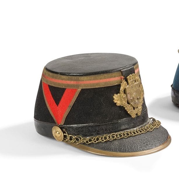 Shako modèle 1872 de la garde Républicaine à pied.
Calotte en cuir noir. Gallon doré et écarlate. Chevrons écarlate brodés doré.
Plaque aux armes de la ville de Paris modèle 1933.
Bourdalou en cuir. 
Fausse jugulaire à anneaux et rosaces à la grenade en laiton.
Mentonnière et coiffe intérieure en cuir noir.
B.E. (Manque la cocarde et le plumet).
