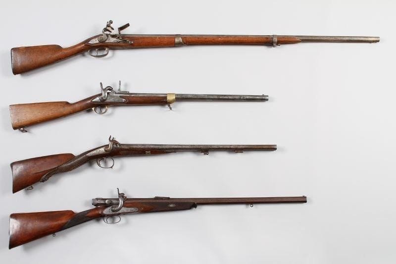Fusil d'infanterie réglementaire à silex du XVIIIè siècle modifié pour la chasse. Long canon rond à méplats au tonnerre, poinçonné. Platine et chien col de cygne à corps plats. Bassinet en fer. Garnitures en fer. Crosse en noyer (Vermoulue, baguette postérieure). E.M. composite.