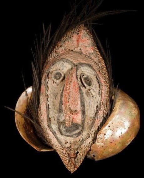 Masque BOIKEN / YANGORU. (Papouasie Nouvelle-Guinée).. «Tacipun», masque en vannerie de jonc, peintures végétales, plumes de casoar, attaché à une coquille d'escargot marin géant (turbo marmoratus), servant de monnaie d'échange ou de dot.. Hauteur:26 cm. Largeur: 20 cm.. Provenance:Village de Yentshun, région Boiken des montagnes, Prince Alexander.
