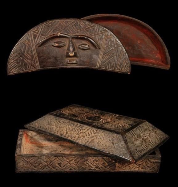 Lot de 2 boîtes à fard KUBA (R.D. Congo). Une grande boîte en forme de croissant décorée de motifs géometriques et d'un visage schématique et une boîte rectangulaire à décor de motifs géométriques et d'une araignée symbolique. Belle patine brune nuancée de grande utilisation.. Longueurs:22 cm et 40 cm.