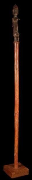 Canne DOGON (Mali). Belle canne en bois à patine brun rouge, ornée en son sommet d'un personnage les bras le long du corps, les mains sur le ventre.. Très belle patine ancienne nuancée.. Hauteur:98 cm.