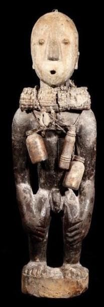 Fétiche EWE (Togo). Sculpture puissante campée sur de petites jambes, des longs bras descendant sur les genoux, torse et ventre couverts de flacons, de cauris et de sacs de fibres, superbe visage à la bouche ouverte en O, couvert d'une patine beige de très grande utilisation.. Collecté in situ en 1982 dans le village de Keta.. Hauteur:49 cm.
