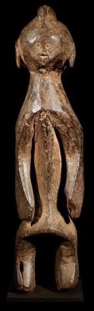 Statuette MUMUYE (Nigéria). Sculpture trapue, puissante, à patine noire très profonde de grande ancienneté. Tête ronde (type 2 de la classification de F. Neyt) à petits yeux et petite bouche, cou fuselé, torse en avant. Erosion de xylophages au coude droit. Style de la région sud.. Hauteur:49,5 cm.