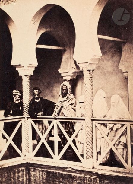 Félix Moulin - Alary et Geiser - J. Trésorier - Dubos Frères - Charles Leinack - Boyer - Richan et divers.
Algérie, c. 1856-1860.
Alger. Maisons mauresques. Rue Porte Neuve. Biskris. Porteur d?eau. Jeunes maures. Perruquier. Mauresques. Femmes arabes. Smaïl Mazary. Tar Mahidîn. Marchands de pain et de poissons. Juifs et juives d’Alger. Monseigneur Pavy Évèque d?Alger. Fontaine de la Porte Neuve. Medjles d?Alger, tribunal supérieur musulman. Entrée des gorges de Chiffa. Blidah. Environs d?Alger. Porte d?Isly. Cabinet du procureur Impérial. Place du Gouvernement. Mosquée Neuve. Descente de la Poissonnerie. Remparts d?Alger. Mosquée de la Marine. Mosquée Sidi Abder Aman. Port d’Alger. Sacrifice de Coqs. École arabe. Aïssa Ouas s’appliquant un fer rouge sur la langue. Derdeba. Partie d?échecs. Jardins d?Essaï, allée des palmiers. Auberge du ravin des Singes. Pont sur la Chiffa. Staoueli. Église de Boufarick. Cimetière arabe dans l?Oued el Kébir. Koléa. Sidi Fermeh. Beni Mered. Oran. Philippeville.
Album petit in-4 oblong, reliure en percaline rouge, composé de 76 épreuves sur papier albuminé contrecollées sur cartons au format carte de visite insérées dans les pages de l’album. Légendes manuscrites et crédits des photographes (étiquettes ou tampons) aux versos. 20 épreuves sur papier albuminé contrecollées sur cartons au format carte de visite sur Marseille par Collé & Vérane en fin d’album.
Format moyen des épreuves : 9 x 6 cm