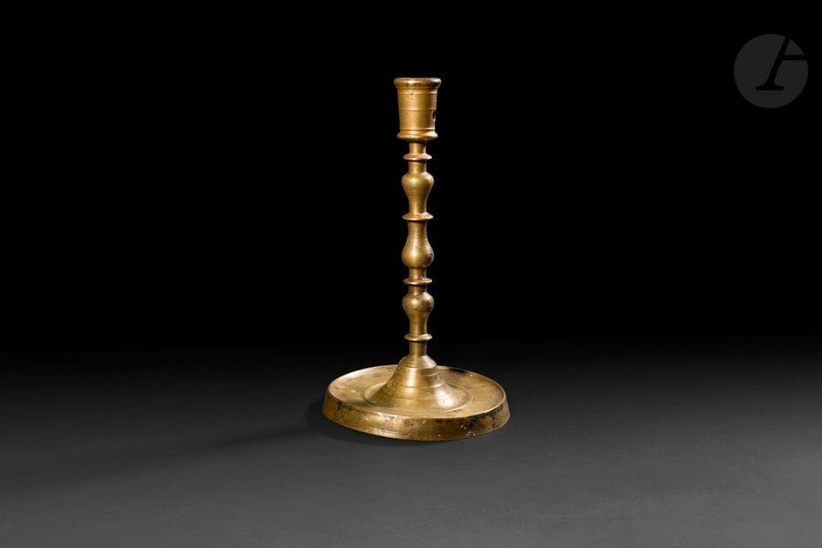 Bougeoir en bronze, fût tourné en balustre, haut binet mouluré repercé, base circulaire.
Flandres, début du XVIe siècle
Hauteur : 28 cm
(petites déformations)