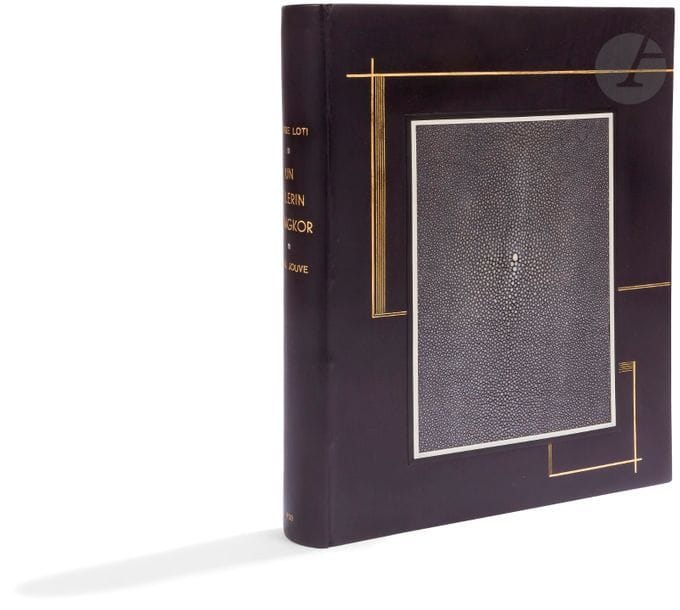 JOUVE (Paul) - LOTI (Peter). A pilgrim from Angkor.
 Paris: Paul Jouve, François-Louis Schmied, 1930. - In-4, 328 x 275: (6 ff.), 142 pp., (5 ff. last blank), 10 plates, illustrated cover. Black box, first plate decorated with horizontal and vertical gold fillets, surrounding a large rectangle of shagreen inlaid in the centre, framed with white bakelite and ebony rods, smooth back, inside framed with gold fillets, lining and endpapers of grey suede bordered with black box, gold head, untrimmed, cover and back preserved, back folder and black box cover bands
, case (M. J. Guian-Milliaud).
 Illustrated edition of 62 compositions by Paul JOUVE (1878-1973) engraved on wood in colour by François-Louis Schmied who also did the printing. There are 13 letterheads, 13 ornaments, 13 headbands, 11 culs-de-lampe, 10 plates and 2
 double-page compositions.
 Edition of 225 copies on vellum by Lana signed by Schmied and Jouve; one of the 200 numbered in
 Arabic numerals.
 Beautiful copy bound by Marie-Josée Guian for her
 personal
 account
.
 A few dumps of the engravings.
