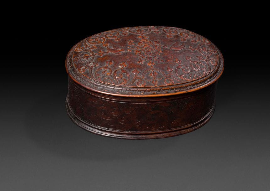Boîte ovale en bois de Sainte-Lucie début du XVIIIe siècle.
Elle est gravée d’enroulements feuillagés sur le pourtour et sculptée sur le couvercle d’entrelacs fleuronnés et d’oiseaux encadrant un vase fleuri.
(Accidents en bordure extérieure et intérieure).
L : 14 cm - l : 9 cm - H : 6,5 cm