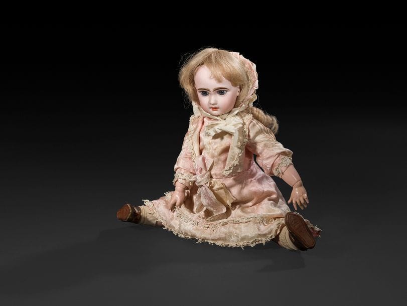 Bébé JUMEAU, T.8, tête en porcelaine sans marque, yeux fixes bleus, bouche ouverte sur une rangée de dents, oreilles percées, perruque blonde. Corps articulé en bois et composition, robe et chapeau en soie rose, (décolorations sur le devant de la robe), souliers d’origine marqués 8 Bébé JUMEAU Déposé.
H : 53 cm