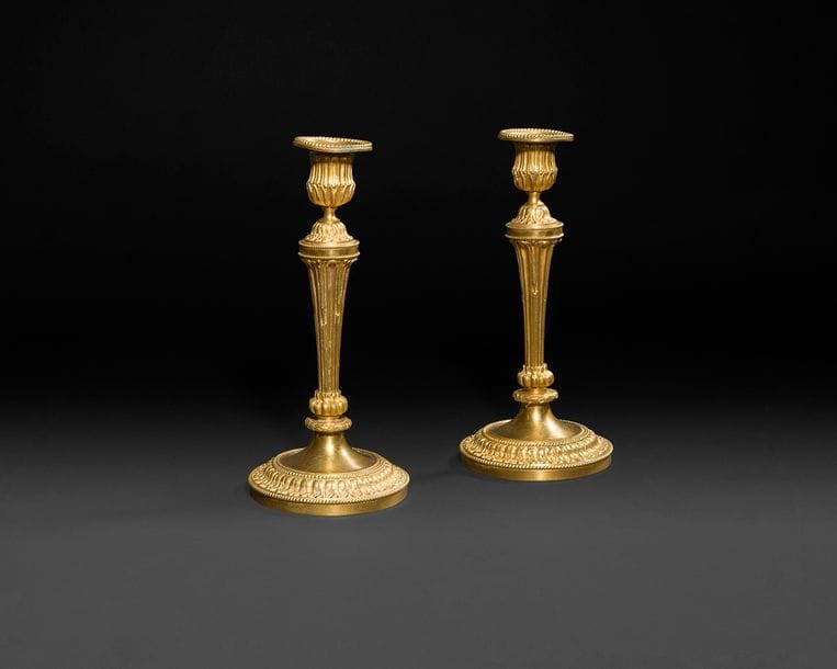 Paire de flambeaux en bronze doré, le fût cannelé reposant sur une base circulaire à frise de feuillages et frise de perles.
Style Louis XVI, XIXe siècle.
H : 24,5 cm