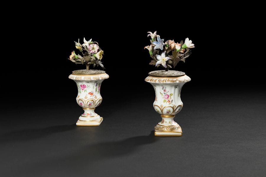 Allemagne
Paire de vases Médicis en porcelaine à décor polychrome de fleurs garnis de fleurs en porcelaine sur des tiges en tôle.
Marque apocryphe de Meissen.
XIXe siècle. 
H : 16 cm