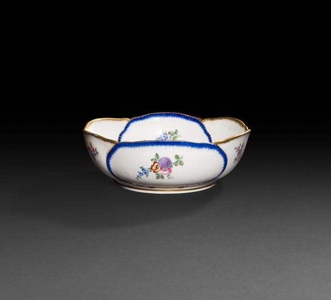Sèvres
Saladier rond à feuilles de chou en porcelaine tendre à décor polychrome de bouquets de fleurs cernés de motifs de feuilles de chou rehaussés de peignés bleu et or.
Marqué : LL entrelacés, lettre-date T pour 1772, marque du peintre Guillaume Noël.
XVIIIe siècle, 1772.
D : 26,5 cm