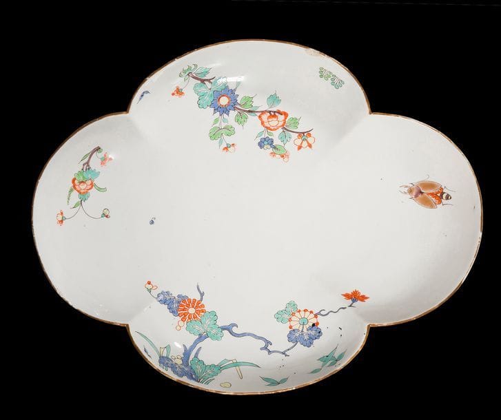 Chantilly
Plateau de sucrier ovale quadrilobé en porcelaine tendre à décor polychrome dans le style Kakiemon de branches fleuries et hannetons.
Marqué : trompe de chasse en rouge.
XVIIIe siècle, vers 1745.
Un éclat.
L : 24 cm