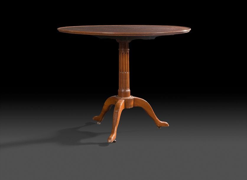 Guéridon en acajou mouluré, le plateau circulaire à rebord, basculant et reposant sur un piétement tripode à fût cannelé.
XIXe siècle.
H : 76 cm, D : 89 cm