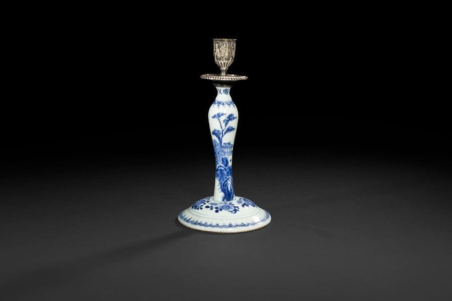 Chine
Flambeau en porcelaine à décor en bleu sous couverte de paysage avec pagode et pin et de fleurs sur la base.
XVIIIe siècle, époque Qianlong (1736-1795). 
La bobèche et le binet en bronze argenté.
H : 27 cm