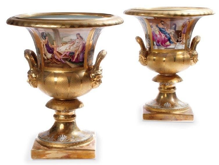 Paire de vases Médicis en porcelaine ornés de deux prises à têtes de lion. Ils reposent sur une base carrée. Décor de scènes à l'Antique polychrome et monogramme M sur un fond or. XIXe siècle. Hauteur: 47 cm - Diamètre: 40 cm.