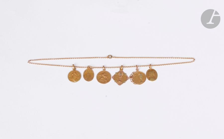 Lot de 5 médailles en or 18K (750) coulissant sur une chaîne en or 18K. Poids : 13,8 g (on joint une médaille en métal doré)