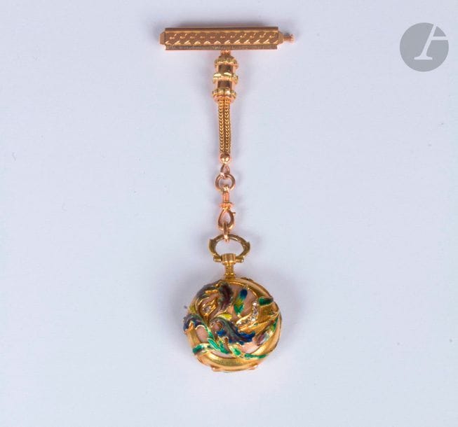 Le COULTRE. Vers 1900. N°81073 
Montre de col en or 18K (750). Boîtier à décor émaillé de fleurs et diamants taillés en rose. Cadran émaillé blanc (accident). Mouvement à remontoir signé. Broche formant pendant en or 18K.
Poids brut : 23,1 g