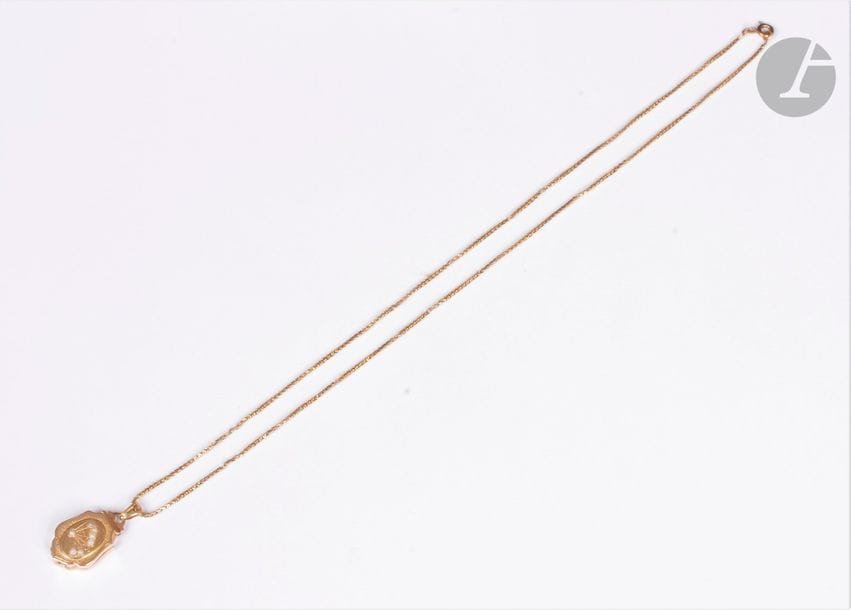 Pendentif ouvrant en or 18K (750), coulissant sur une chaîne en or 18K. Poids brut : 11,3 g