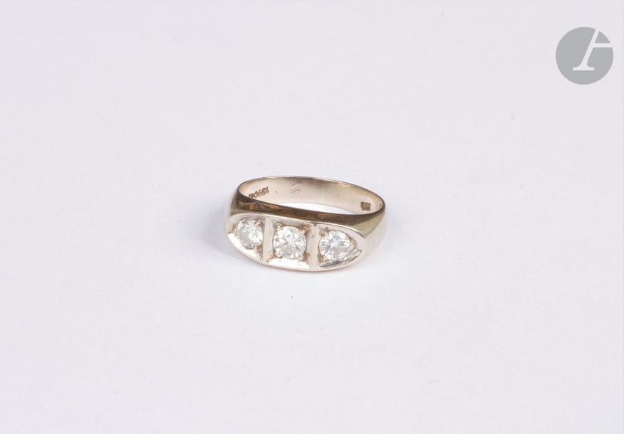 Bague en or gris 18K (750), sertie d'une ligne de trois diamants de taille brillant. Tour de doigt : 49. Poids brut : 4,4 g