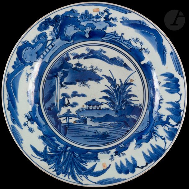 Japon
Plat rond en porcelaine à décor en camaïeu bleu de paysages lacustres avec pagodes. 
Fin du XVIIe siècle, début du XVIIIe siècle. 
D : 39 cm