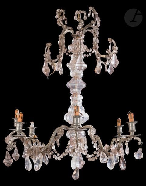 Lustre en étain et fer argenté, cristal de roche et verre taillé, à huit bras de lumière mouvementés, à décor de gouttes, pendeloques et rosette ; (percé pour l’électricité) ; (composé d’éléments anciens).
XIXe siècle (accidents, manques et restaurations)
H : 70 cm, D : 67 cm