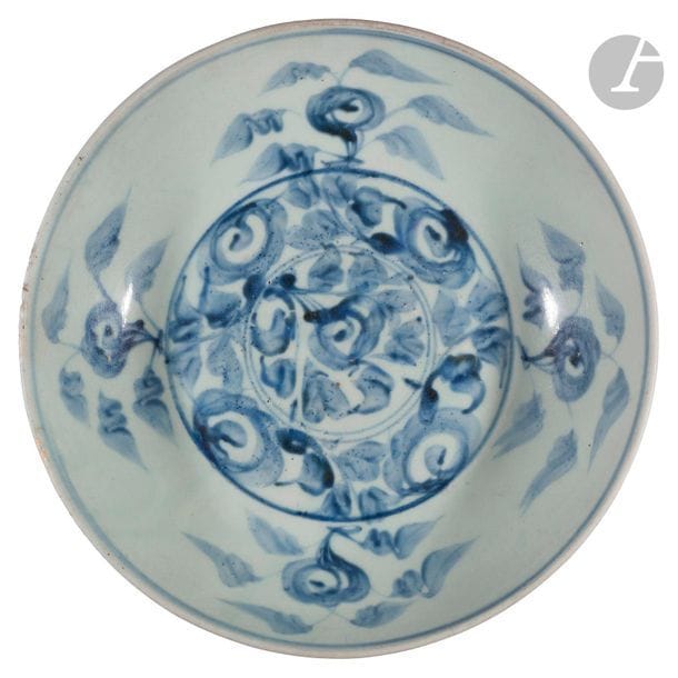 CHINE, Fours de Swatow (Zhangzhou) - Époque MING (1368 - 1644)
Plat rond en grès décoré en bleu sous couverte de fleurs stylisées dans un médaillon central et de branches fleuries en réserve. (Égrenures en bordure du plat).
Diam. 32,5 cm