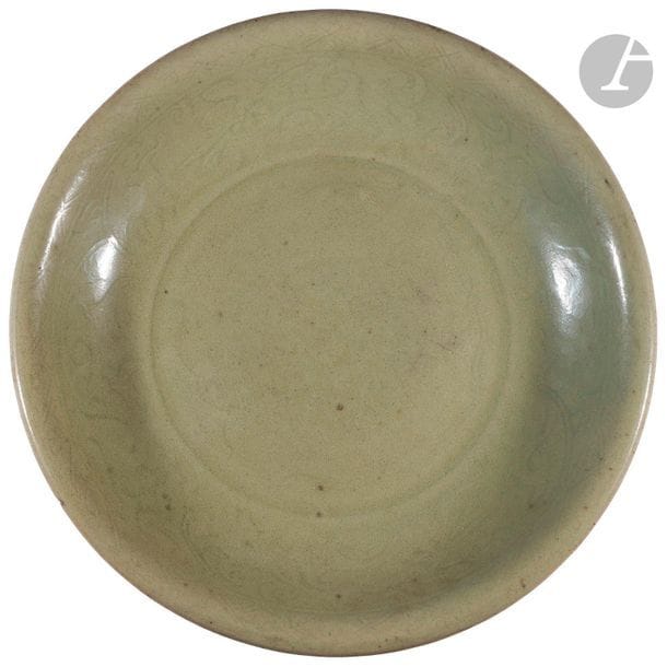 CHINE, Fours de Longquan - Époque MING (1368 - 1644)
Plat rond en grès émaillé céladon vert incisé sous la couverte de motifs de fleurs stylisées. 
Diam. 35,3 cm