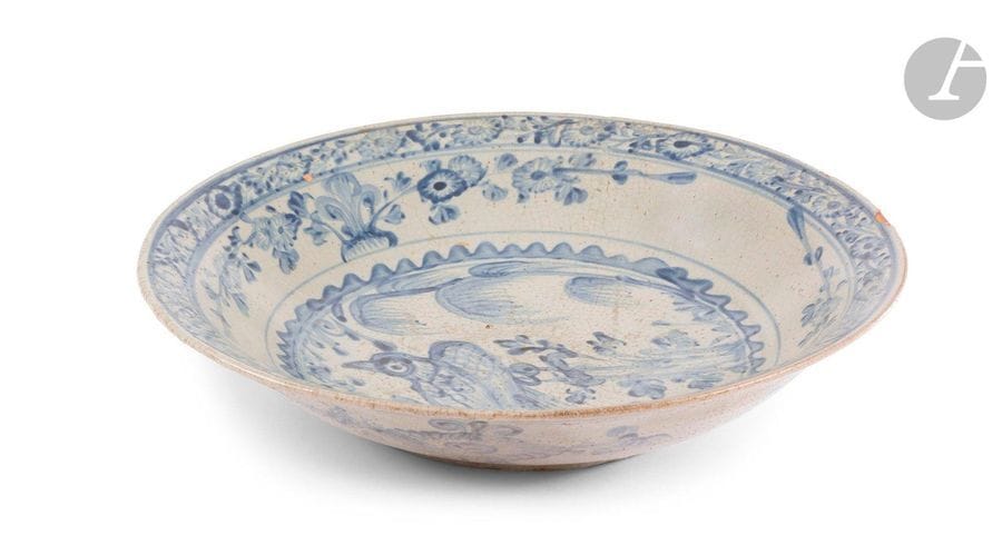 CHINE, Fours de Swatow (Zhangzhou) - Époque WANLI (1573 - 1620)
Plat rond en porcelaine bleu blanc à décor central d’un oiseau perché sur un rocher, de frise de branches fleuries en réserve. (Fêlures, égrenures, saut d’émail).
Diam. 41,4 cm