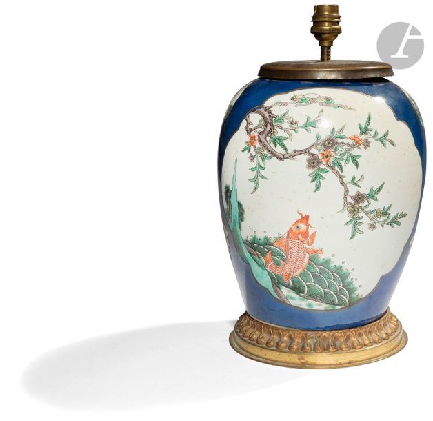 CHINE - Fin XIXe siècle
Vase balustre en porcelaine blanche à décor polychrome en bleu et or et émaux de la famille verte dans des médaillons polylobés d’oiseau perché sur une branche fleurie sur une face, d’une carpe sortant des eaux sur l’autre face, de branches et de rochers fleuris à l’épaulement. (Col coupé, monté en lampe, état non garanti sous la monture en bronze doré). 
H. 28 cm