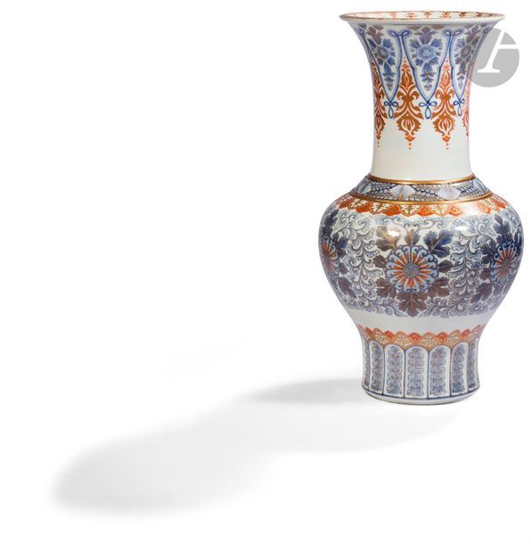 JAPON - Époque MEIJI (1868 - 1912)
Grand vase balustre à col évasé à décor en bleu sous couverte et émaux rouge de fer et or de fleurs de lotus stylisées parmi les rinceaux feuillagés, le col et le pied ornés de végétaux stylisés. (Usures de l’émail au col, égrenures).
H. 55,5 cm