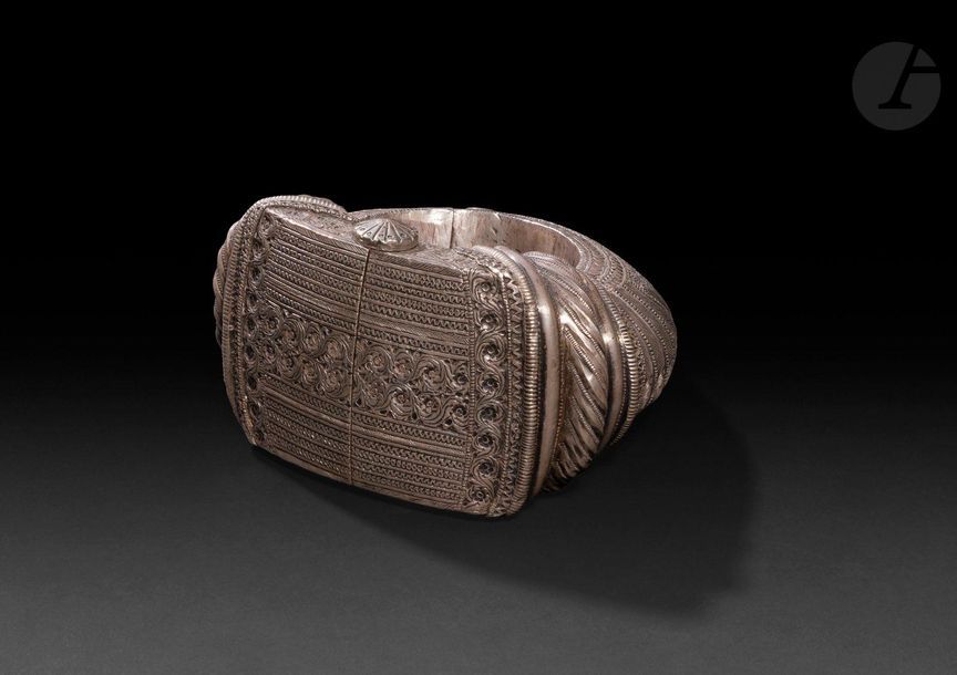 Important bracelet natla, Oman, Nizwa, XXe siècle
En argent à décor moulé et gravé de rinceaux, fleurons végétaux et frises géométriques de tresses, de chevrons et d’ocelles. Fermoir charnière à tige.
Diamètre extérieur : 13 cm ; diamètre intérieur : 6,5 cm, largeur max. : 7 cm ; poids : 580,9 g

Bibliographie :
Van Cutsem Anne, Bracelets ethniques d’Afrique, d’Asie, d’Océanie et d’Amérique, Paris, Skira : 2002, p. 145.

An important bracelet natla, Oman, Nizwa, 20th century
