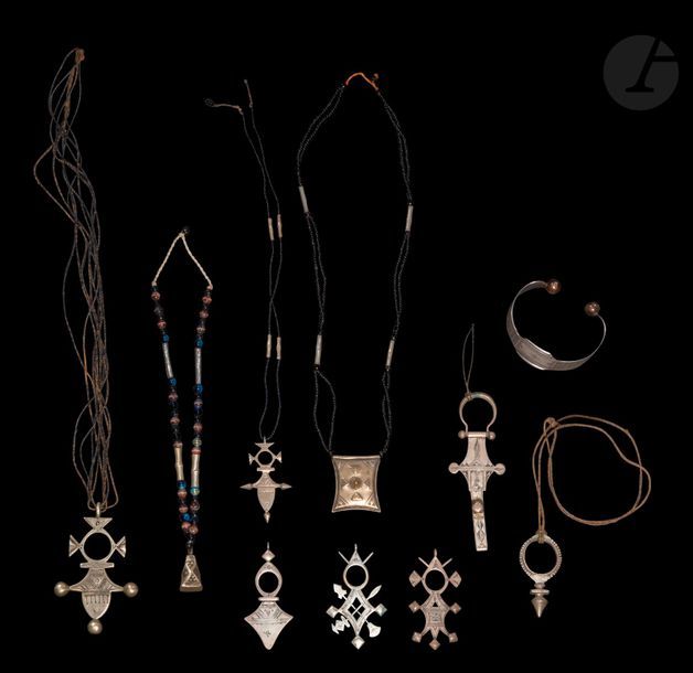Dix bijoux sud-sahariens, Touareg, XXe siècle
En argent et alliage cuivreux, colliers de perles de verroterie noire ou liens en cuir. Six croix du Niger tanayilt, dont une croix de Zinder, une de Bilma, deux d’Iferouane, une d’Aïr, probablement une clé de voile tassarut, un pendentif porte-amulette tcherot, un pendentif de forme pyramidale, un bracelet rigide.
Voir V. Beltrami, « Croix d’Agadez », Encyclopédie berbère, 14 | 1994, 2129-2133 ; A. Durou, Bijoux nomades : le paysage aux sources de l’inspiration, Genève, Aubanel, 2006.
De 3 à 8 cm 
Poids brut : 224 g

10 pieces of Tuareg jewellery, 20th century