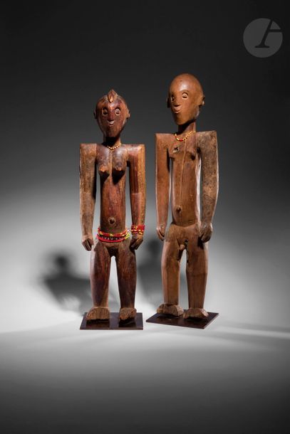 Un rare couple de statuettes se tenant debout, la femme arbore une coiffure en crête rasée. 
L'histoire de la collecte de ces deux sculptures, en deux temps, explique les différences de patine sur un bras de chaque sculpture ; comme il était parfois de coutume, un bras de chaque sculpture cédée pouvait être cassé et rester planté sur l'autel familial, que celle-ci a finalement cédé plus tard.
Tieffo (aire Toussian), Burkina Faso
Bois dur caractéristique de ce groupe, perles, fentes d'ancienneté et manques en parties basses (casses anciennes), et bras d'origines cassés-collés, belle patine blonde d'usage 
H. : 60 et 56 cm

Provenance :
Collection Emmanuel Bordier