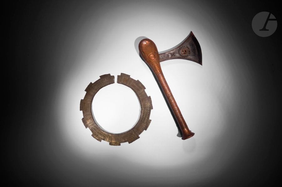 Un lot réunissant un ancien et très beau torque, collier de chef, à décors gravés, et une hache à décors ajourés et gravés au manche recouvert de cuivre.
Voir : n° 31 page 62 dans Art de L'Afrique Noire Au Pays Du Fleuve Zaïre par Joseph Cornet, pour un torque comparable.
Téké, République Démocratique du Congo
Métal, laiton, cuivre, et bois, une étiquette d'une ancienne collection subsiste à l'arrière du torque, très belle patine d'usage du torque 
D. : 27,5 cm
H. : 39 cm