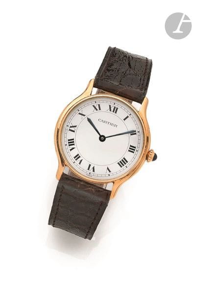 CARTIER. Vers 1970
N° 107130177
Montre bracelet pour homme en or jaune 18K (750), cadran blanc (trés légérement craquelé) index chiffres romains formant les heures, mouvement à remontage mécanique Cartier 107 calibre Peseux 7001, bracelet cuir avec sa boucle déployante en or 18K signée.
Cadran, boîtier et mouvement signés.
Diamètre : 30 mm
Poids brut : 32,5 g