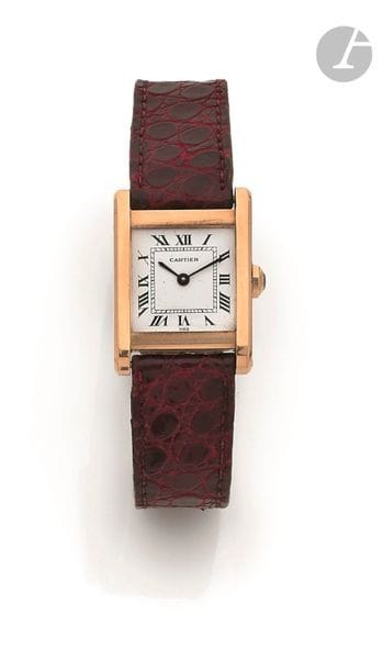 CARTIER Tank. Vers 1970
N° 780920171 
Montre bracelet pour homme en or jaune 18K (750), cadran blanc, index chiffres romains formant les heures, mouvement à remontage mécanique signé, calibre ETA 2512-1, bracelet cuir boucle ardillon en or jaune signée.
Cadran, boîtier et mouvement signés.
La montre est accompagnée d’une boucle déployante signée en or (Poids : 10 g).
Diamètre : 22 mm x 30 mm 
Poids brut : 28,5 g