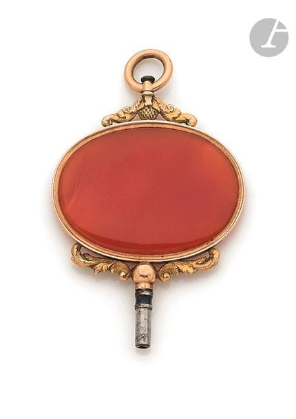 Clé de montre en or jaune 18K (750), ornée d’un médaillon en cornaline.
Diamètre : 40 mm
Poids brut : 15,6 g