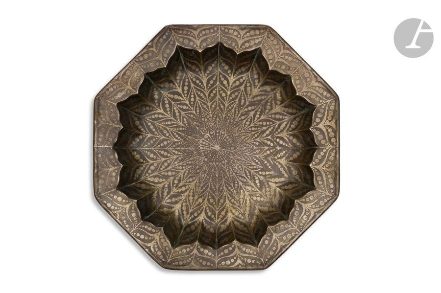 JEAN DUNAND (1877-1942
)Motifs
 feuillagés stylisés, 1914Plat

 octogonal ; le centre traité en creux et le pourtour évoquant

 un motif floral stylisé.

 Épreuve en dinanderie de

 cuivre montée au marteau.

 Décor argent vieilli en réserve sur

 fond patiné brun.

 Signé et daté Jean DUNAND 1914 et porte le poinçon de dinandier J

. D. au revers.

 Longueur : 28cm -

 Largeur : 28cmBibliographie : 
Jean Dunand, vie et œuvre- Félix Marcilhac, Les éditions de l'Amateur, Paris, 1991.Variantes de décor reproduit les pages 269 et 270 (catalogue des œuvres).
