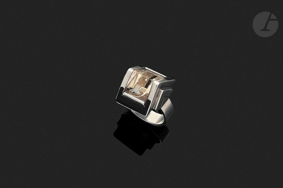 ÉTIENNE COURNAULT (1891-1948) & JEAN DESPRÉS (1889-1980) Sans titre, vers 1930Exceptionnelle bague moderniste ; la monture en argent et laque noire.
 La plateforme en prisme triangulaire
 reçoit un cabochon en glace peinte et gravée.

 Les parties latérale

s

 figurant des triangles décroissants évoquant des chevrons. Une infime restauration sur l'arête du cabochon.
 Signée J. DESPRÉS à la pointe à l'intérieur de l'anneau et porte les poinçons de Maître Orfèvre
 et de garantie à l'extérieur de l'anneau. Poids brut : 15 gProvenance
:- Nièce d'Étienne Cournault
 ; œuvre reçue en présent. -

 Par descendance, fille de la précédente, petite-nièce

 d'Étienne Cournault. Exposition : 
Étienne Cournault (1891-1948) - Musées de la Cour d'Or à Metz, du 25 juin au 24 octobre 1994. Notre œuvre présentée lors de cette manifestation sous le
 numéro 94 du catalogue.
 Bibliographie et œuvres
 en rapport

:- Étienne Cournault (1891-1948) - Collectif, catalogue de l'Exposition organisée du 25 juin au 24 octobre 1994 aux Musées de la Cour d'Or à Metz, Éditions La Cour d'Or - Éditions Serpenoise, 1994. Notre œuvre référencée sous le numéro 94 et reproduite à la

 page 135

 - Étienne Cournault (1891-1948) - La part du rêve - Collectif, catalogue des expositions éponymes organisées à Nantes et Nancy en 2016, éditions Snoeck, 2015. Des œuvres de collaboration entre Étienne Cournault et Jean
 Després
 reproduit la page

 67

 - Jean Després, maestro orafo tra art deco e avanguardie - Melissa Gabardi, Idea Books, Milano, 1999. Des œuvres de collaboration entre Étienne Cournault et Jean Després reproduit les pages 44 à 53.


