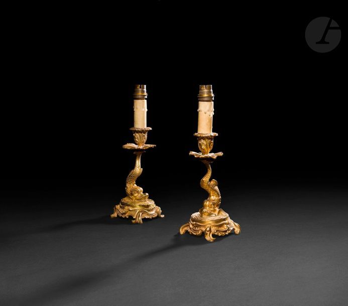 Paire de flambeaux en bronze doré, le fût en forme de dauphin, reposant sur une base feuillagée ; (percés pour l'électricité).

XIXe siècle.

H : 20 cm