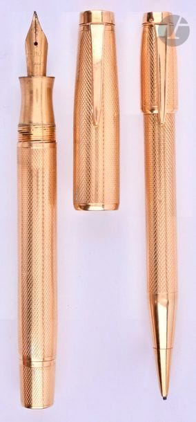 Parure stylo plume + stylo mine en or 18 carats de forme ronde. Réalisée par le joaillier parisien Lefebvre. Décor de lignes ondulées. Plume or 18 carats Penor, remplissage par bouton poussoir (poche à changer). Mécanisme mine par capuchon poussoir (à revoir, la gaine du capuchon tourne). Petits coups et micro-rayures.
Longueur du plume : 138 mm - Poids brut de la parure : 62 g