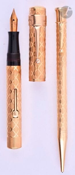 WATERMAN / JIF
Parure stylo plume 5552 + stylo mine en or 18 carats. Habillage français décor X (lignes et croisillons) sur ébonite noire. Plume or n° 2, remplissage levier (poche à changer). Bague agrafe en 9 carats. Système mine tournant. Micro-rayures. 
Longueur : 114 mm - Poids brut : 50 g
