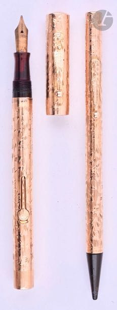 WATERMAN
Parure stylo plume 552 ½ LEC + stylo mine en or 14 carats décor Hand Engraved Vine. Initiales sur le corps du mine. Plume or n° 2, remplissage levier (poche à changer). Petits coups et micro-rayures. 
Longueur : 129 mm - Poids brut : 34 g