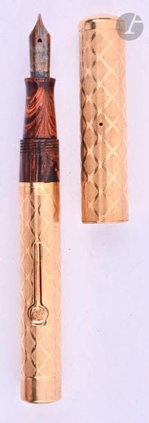 WATERMAN
Stylo plume 5552 en or 18 carats. Habillage français décor X (lignes et croisillons) sur ébonite marbrée. Plume or n° 2, remplissage levier (poche à changer). Micro-rayures. 
Longueur : 109 mm - Poids brut : 24 g