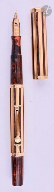 WATERMAN
Stylo plume 552 ½ en or 18 carats. Habillage français décor J (ajouré droit) sur ébonite marbrée. Plume or n° 2, remplissage par levier (poche à changer). Micro-rayures. 
Longueur : 132 mm - Poids brut : 20 g