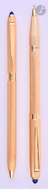 Parure stylo bille + stylo feutre en or 18 carats. Réalisée par le joaillier parisien Lefebvre. Décor grain d’orge et une pierre lapis est sertie au sommet des capuchons. Bille système tournant. Micro-rayures.
Longueur du bille : 133 mm - Poids brut de la parure : 54 g