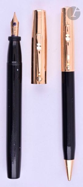 CARTIER
Parure stylo plume et stylo mine. Corps en résine noire et capuchons en or 14 carats décor lisse. Plume or 14 carats, remplissage par pompe (poche à changer). Mine système tournant. Petits coups et micro-rayures. 
Longueur : 135 mm - Poids brut : 38 g
