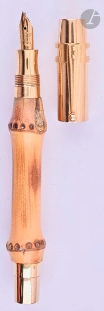 CARTIER
Stylo plume en or 18 carats et bambou pour le corps. Réalisé par le joaillier parisien Lefebvre. Plume en or 18 carats Onoto, remplissage par bouton poussoir (poche à changer). Bague agrafe Waterman en or 18 carats au capuchon. Petits coups et micro-rayures. 
Longueur : 116 mm - Poids brut : 20 g
