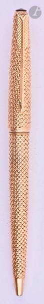 CARTIER
Stylo bille en or 18 carats décor tressé. Sur une base de Parker 61. Mécanisme par capuchon poussoir. Micro-rayures. 
Longueur : 131 mm - Poids brut : 30 g
