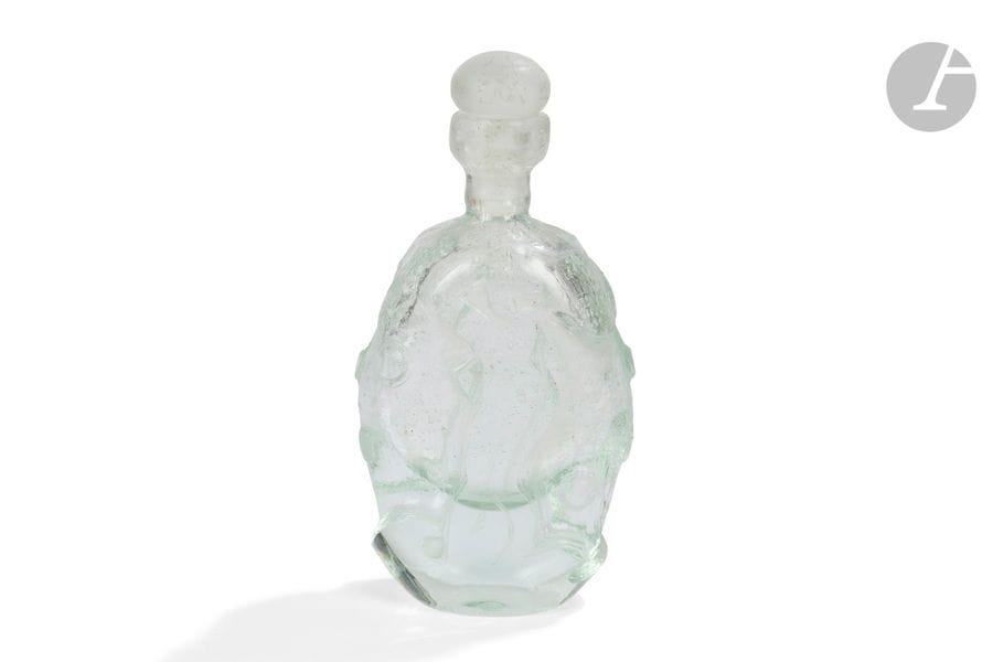 RENÉ DENIEL (NÉ EN 1947) 
Nus féminins 
Flacon ovoïde méplat. Épreuve en verre teinté vert d’eau, le décor double face dégagé à l’acide et à la taille. Bouchon sphérique aplati en verre dépoli. Deux égrenures sous la base. Signé R. DENIEL France et porte la référence A1 vers la base. H. 23 cm 